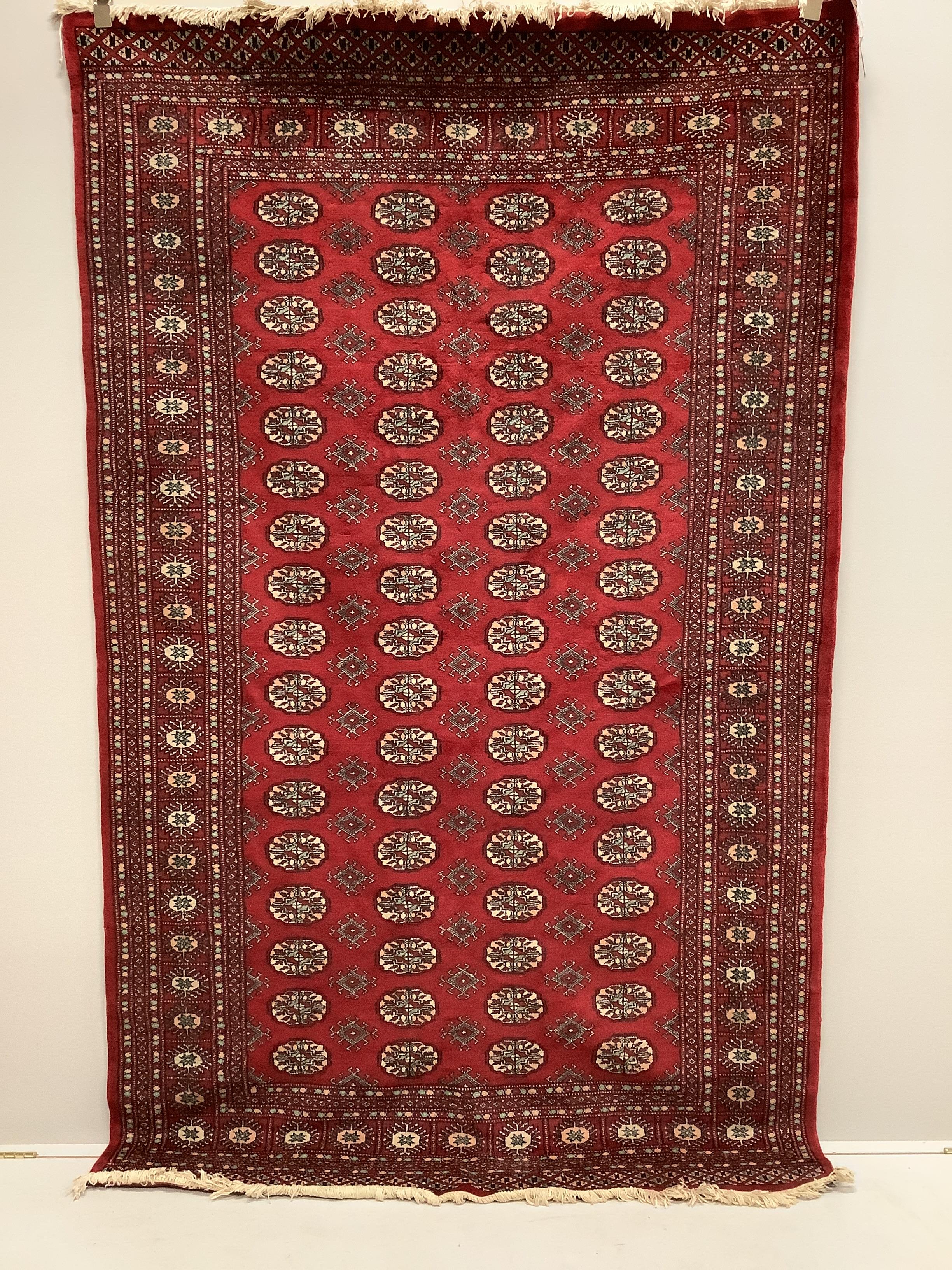 A Bokhara red ground rug, 250 x 155cm